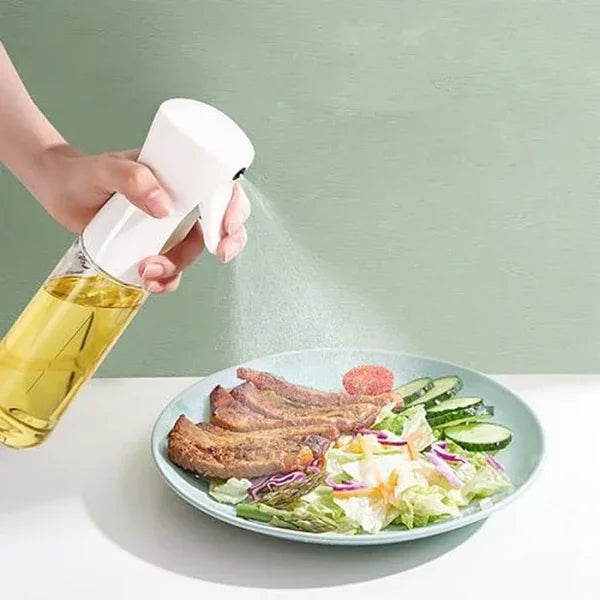 Hand using oil spray bottle to mist salad and meat on plate, sunehri store
