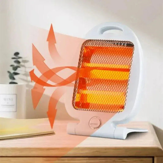 Mini electric fan heater on wooden table emitting warm air with glowing heating elements